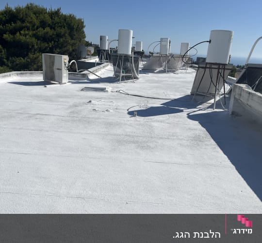 גג אטום בלבן עם דודי שמש וצנרת